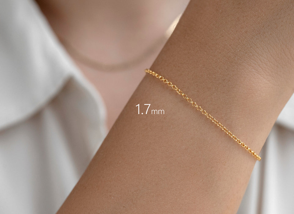 Gold bracelet on a wrist with a measurement label indicating 1.7mm width, against a neutral background.