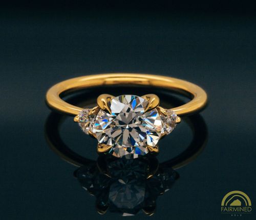 Photo of Round Diamond Three-Stone Engagement Ring Semi-Mount in Fairmined Yellow Gold from RIVA Precision