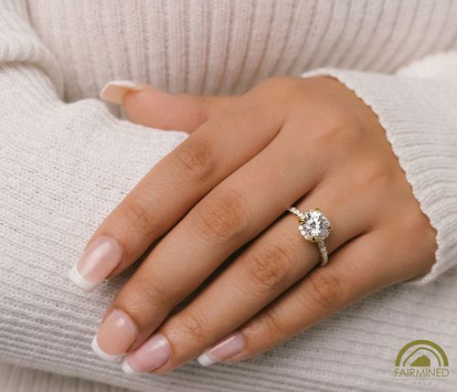 Hand model wearing Round Diamond Halo and Pavé Shank Engagement Ring Semi-Mount in Fairmined Yellow Gold from RIVA Precision