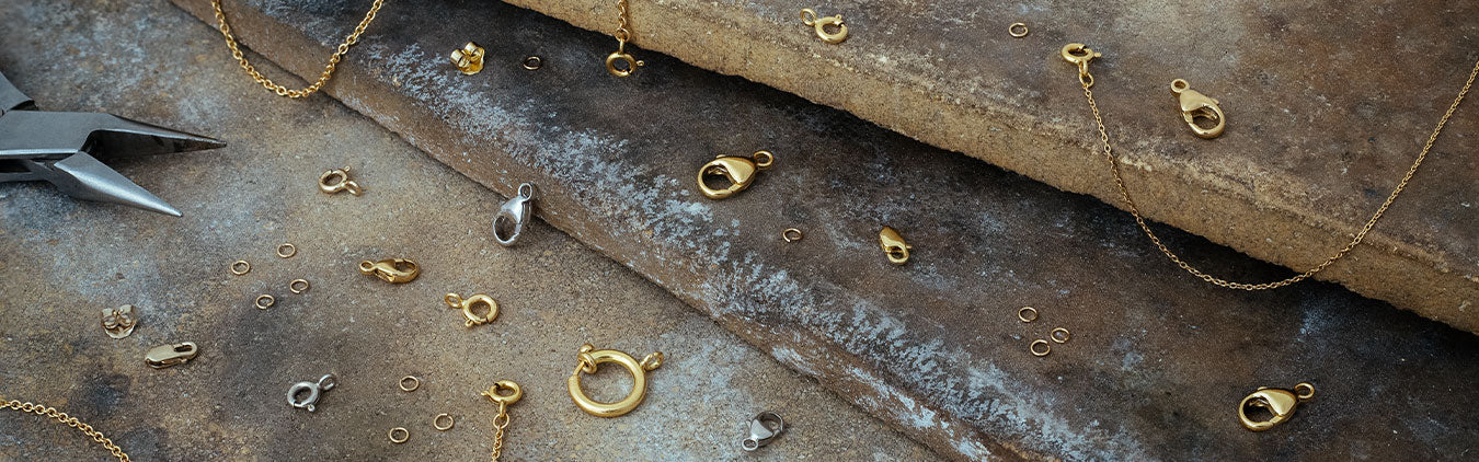Findings and lobster claw clasp scattered on table