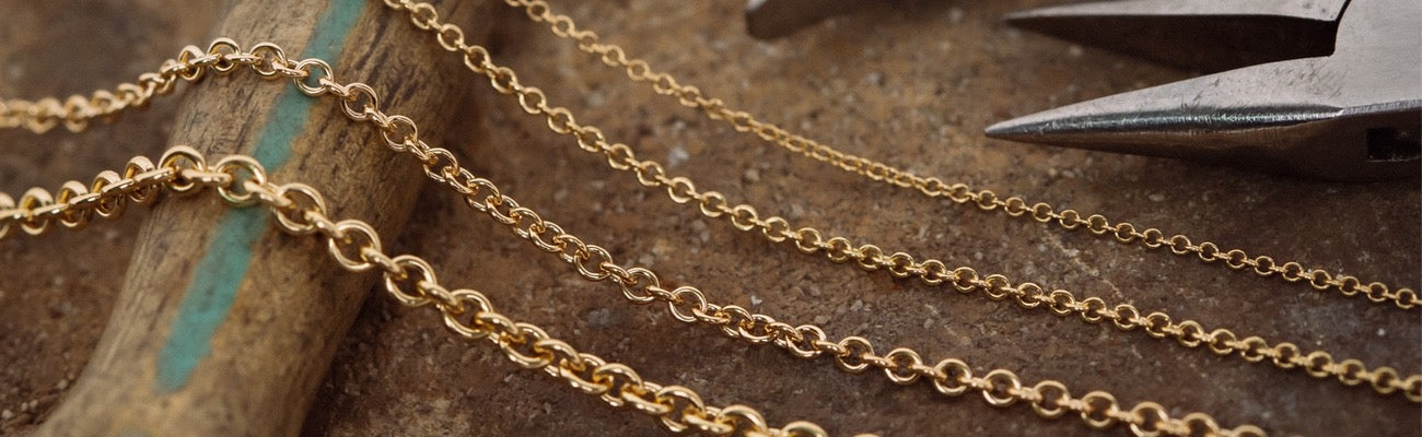 Four 14k gold Cable Chains on table