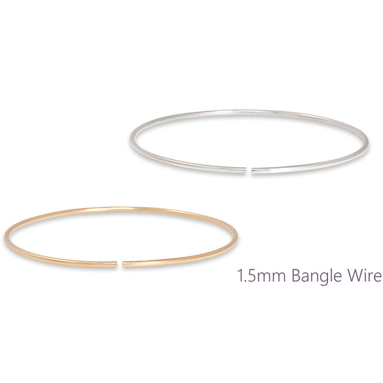 Two bangle wires, one gold and one silver, on a white background.