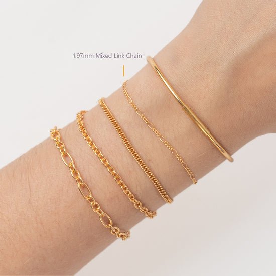 Gold bracelets on a wrist with a plain background