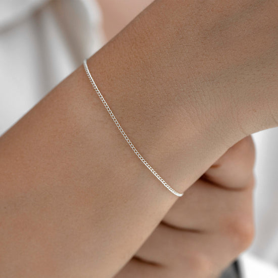 Silver bracelet on a wrist with a blurred background