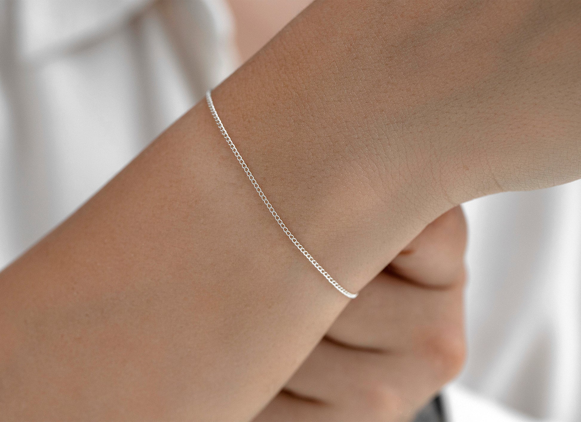 Silver bracelet on a wrist with a blurred background