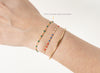Close-up of a wrist wearing three bracelets on a white background