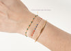 Close-up of a wrist wearing three bracelets on a white background
