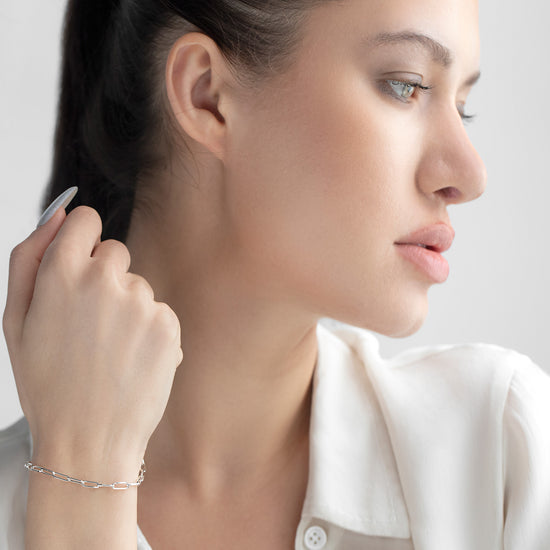 Woman adjusting her hair with a neutral background