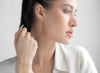 Woman adjusting her hair with a neutral background