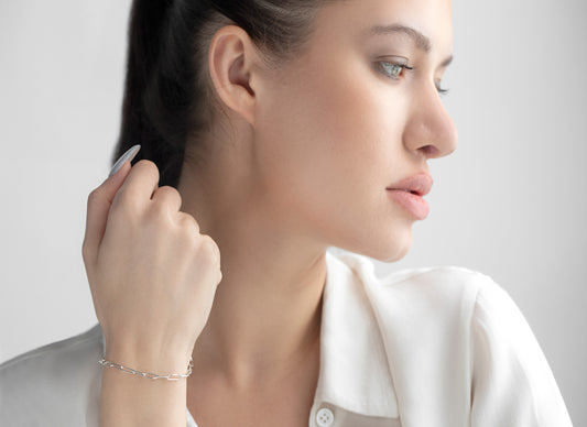 Woman adjusting her hair with a neutral background