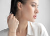 Woman adjusting her hair with a neutral background