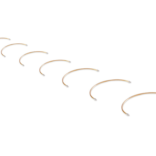 Set of gold half cuff bracelets on a white background