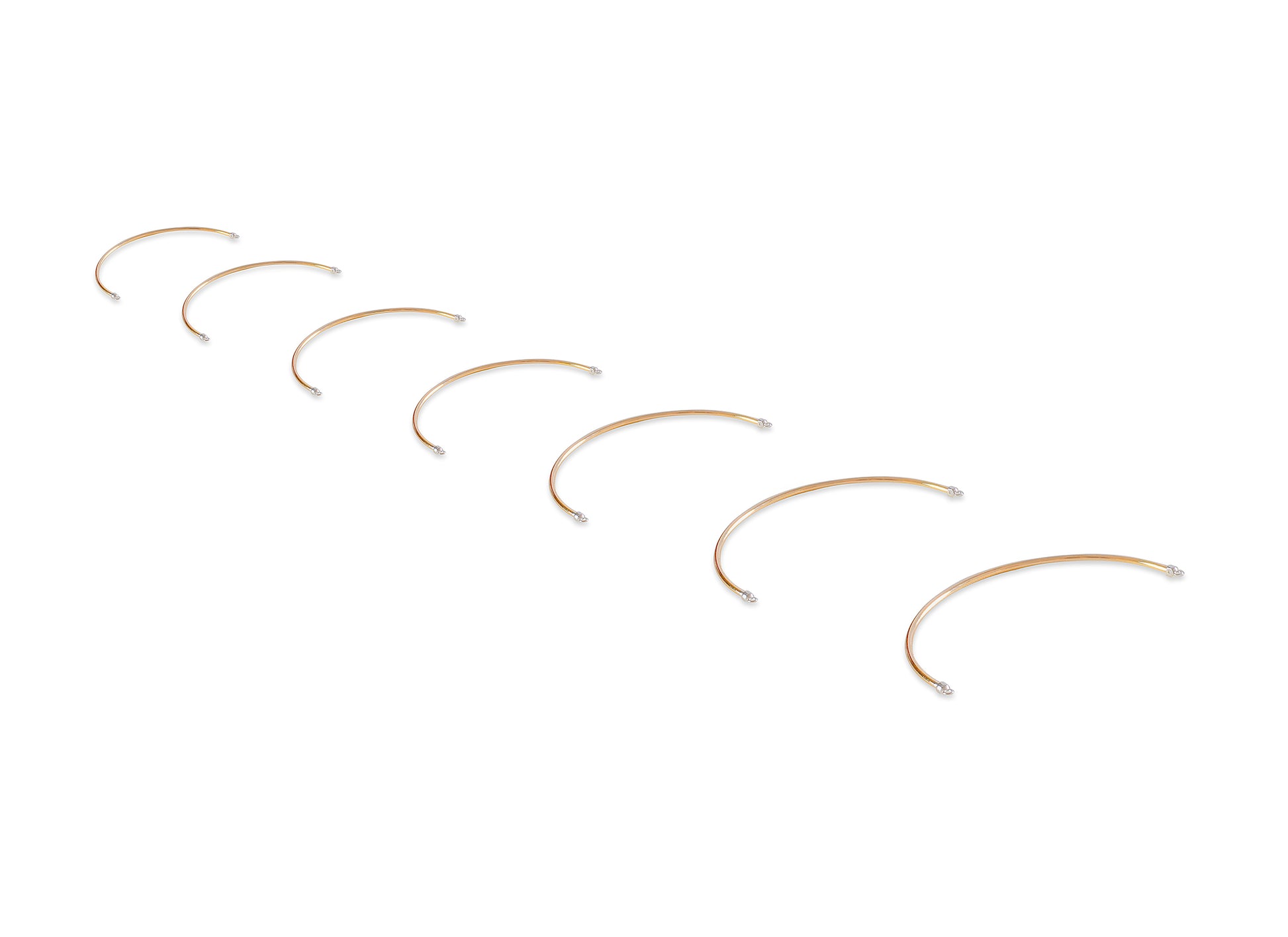 Set of gold half cuff bracelets on a white background