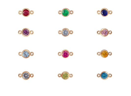 Gold jewelry connectors with colorful gemstones on a white background