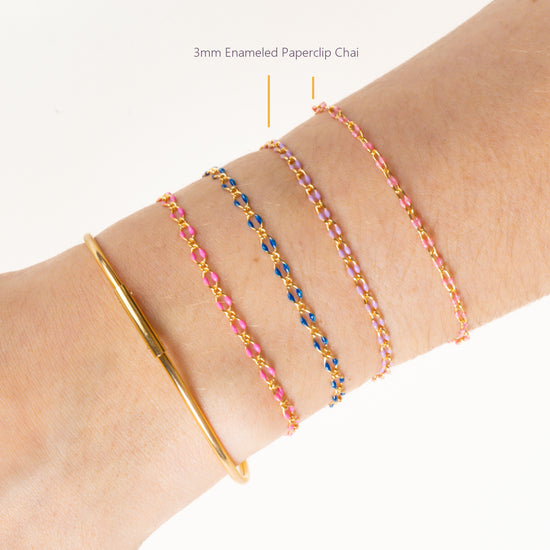 Close-up of a wrist wearing multiple bracelets on a white background