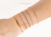Close-up of a wrist wearing multiple bracelets on a white background