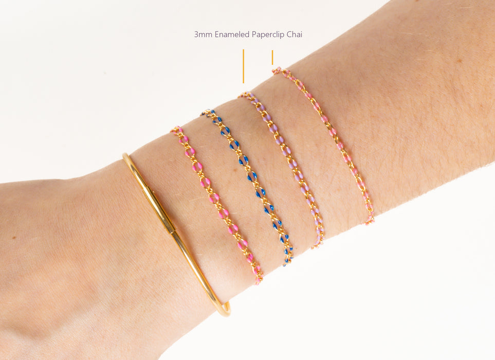 Close-up of a wrist wearing multiple bracelets on a white background