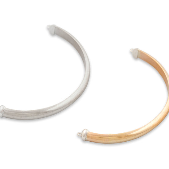 Two necklaces, one white and one beige, on a white background