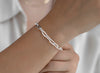 Silver 5mm chain bracelet on a wrist with a blurred background