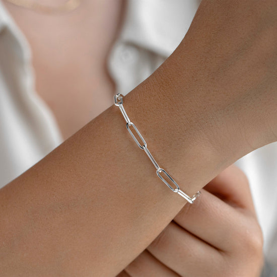 Silver chain bracelet on a wrist with a blurred background