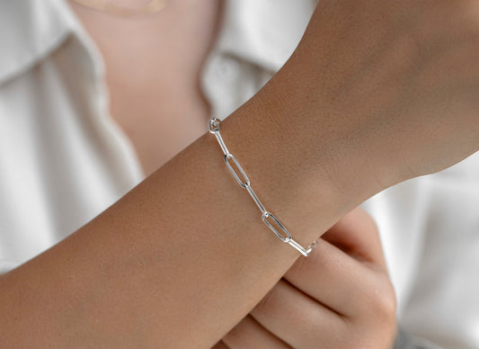 Silver chain bracelet on a wrist with a blurred background