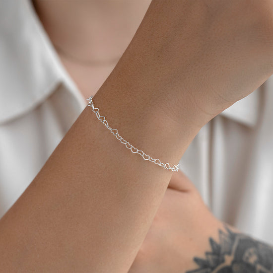 Silver chain on a wrist with a neutral background