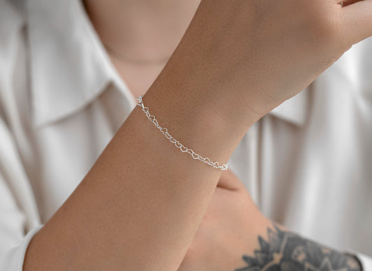 Silver chain on a wrist with a neutral background
