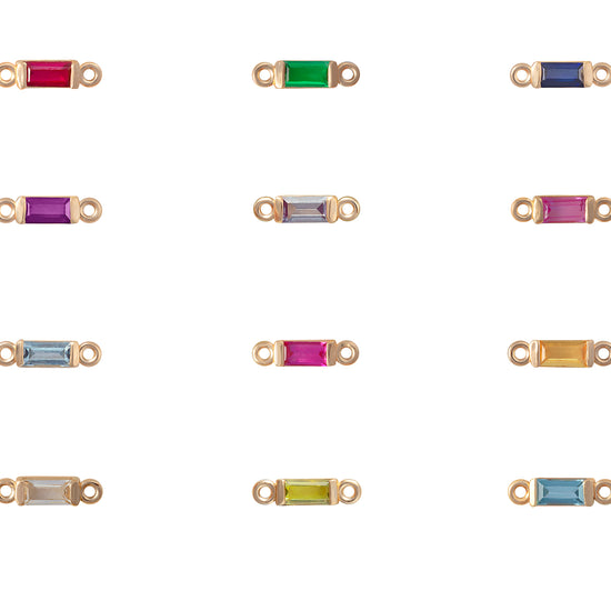 Gold jewelry connectors with colored gemstones on a white background