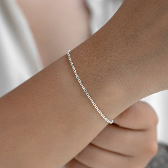Silver bracelet on a wrist with a blurred background