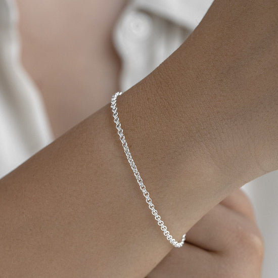 Silver bracelet on a wrist with a blurred background