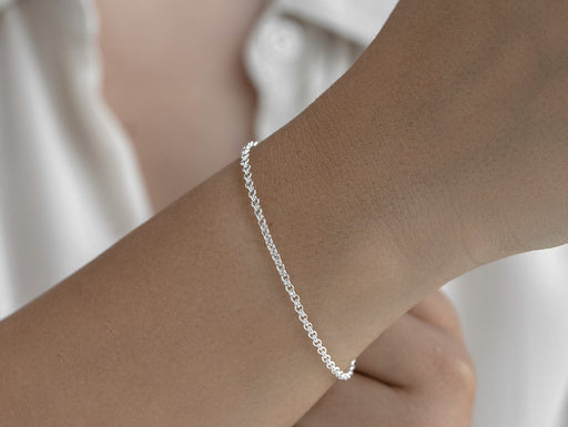Silver bracelet on a wrist with a blurred background