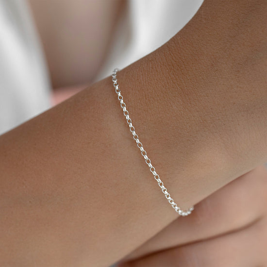 Silver 1.8mm bracelet on a wrist with a blurred background