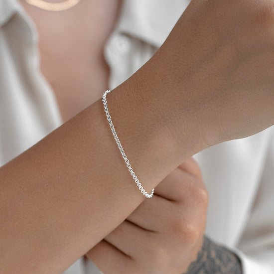 Silver bracelet on a wrist with a blurred background