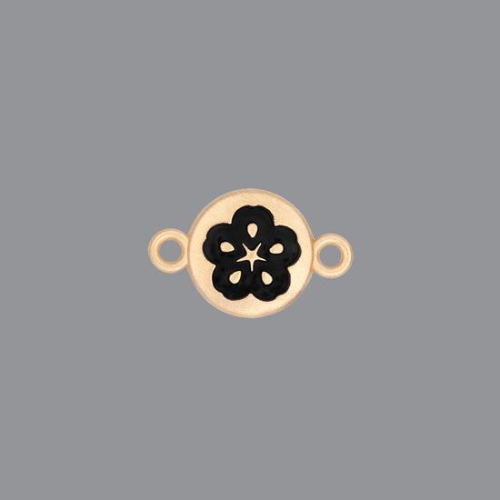 Round emoji connector in gold with a flower engraving on gray background