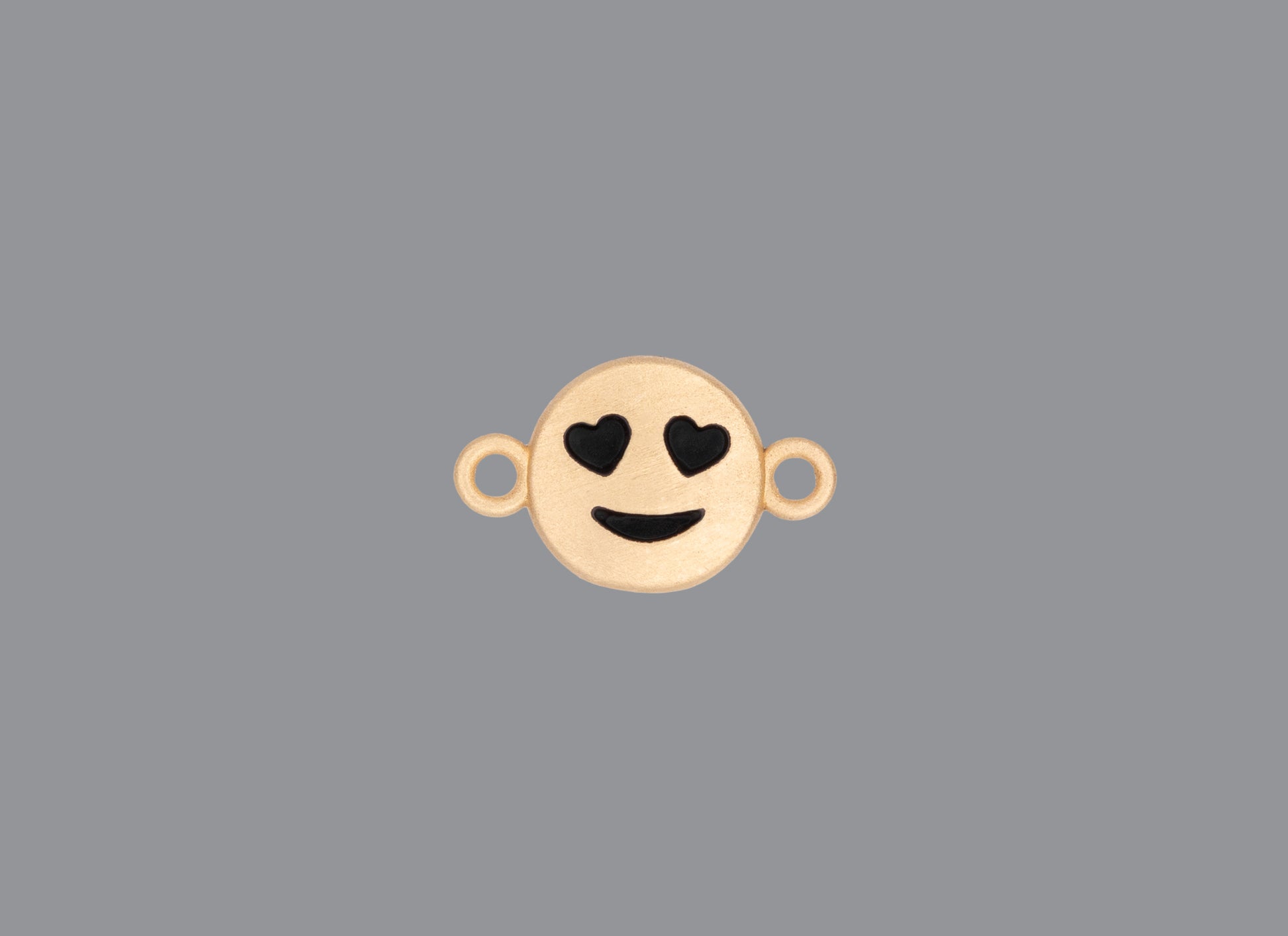 Round emoji connector in gold with a smile engraving on gray background