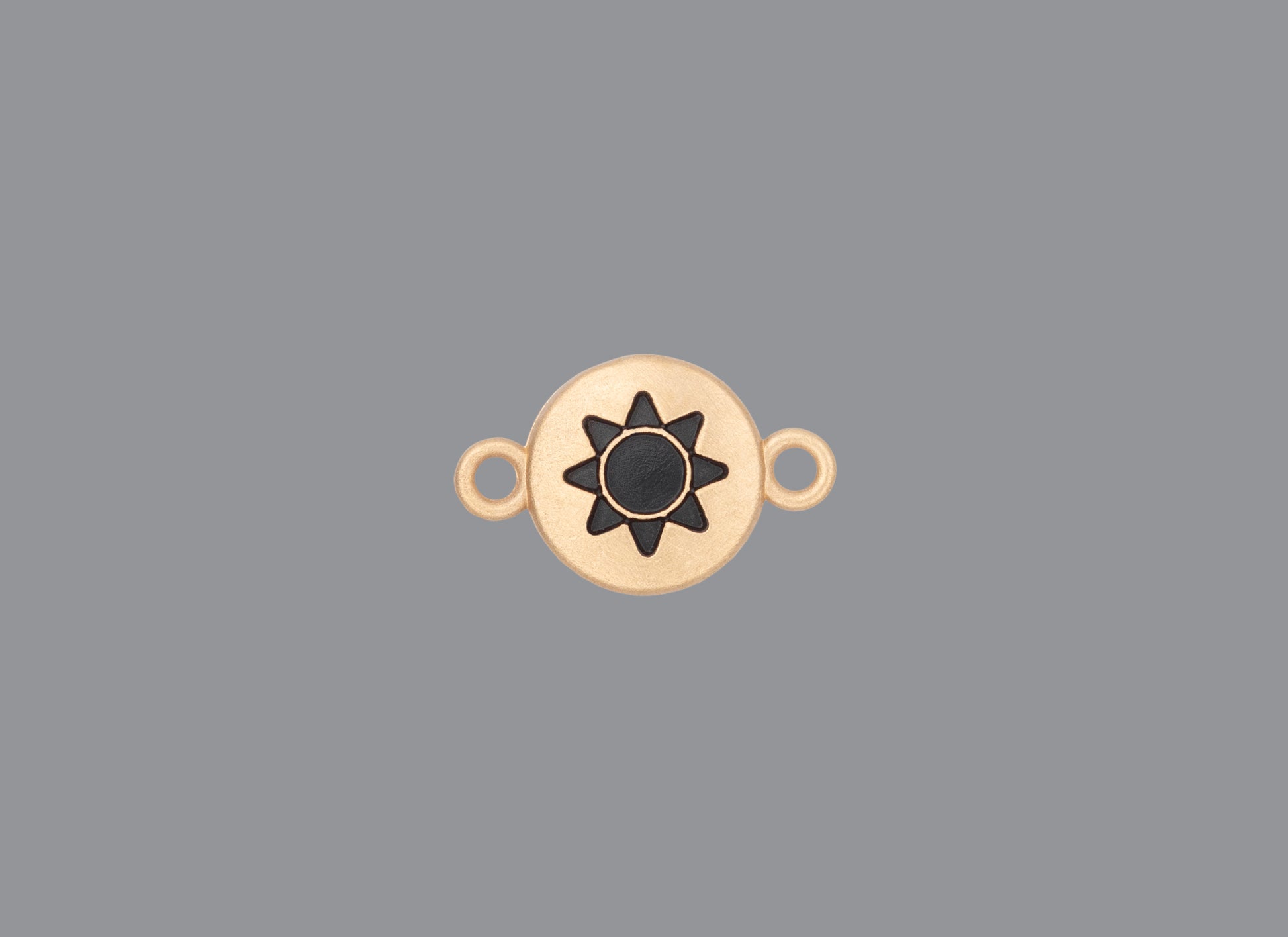Round emoji connector in gold with a sun engraving on gray background