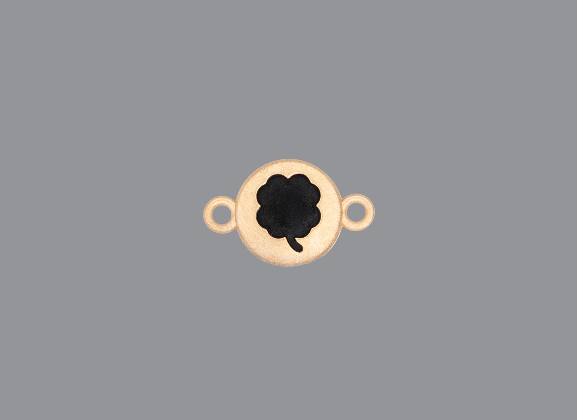 Round emoji connector in gold with a clover engraving on gray background