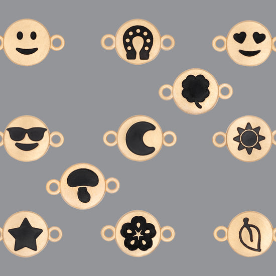 A collection of round emoji connectors with a satin finish in various designs, including smiley faces, hearts, stars, and floral patterns.