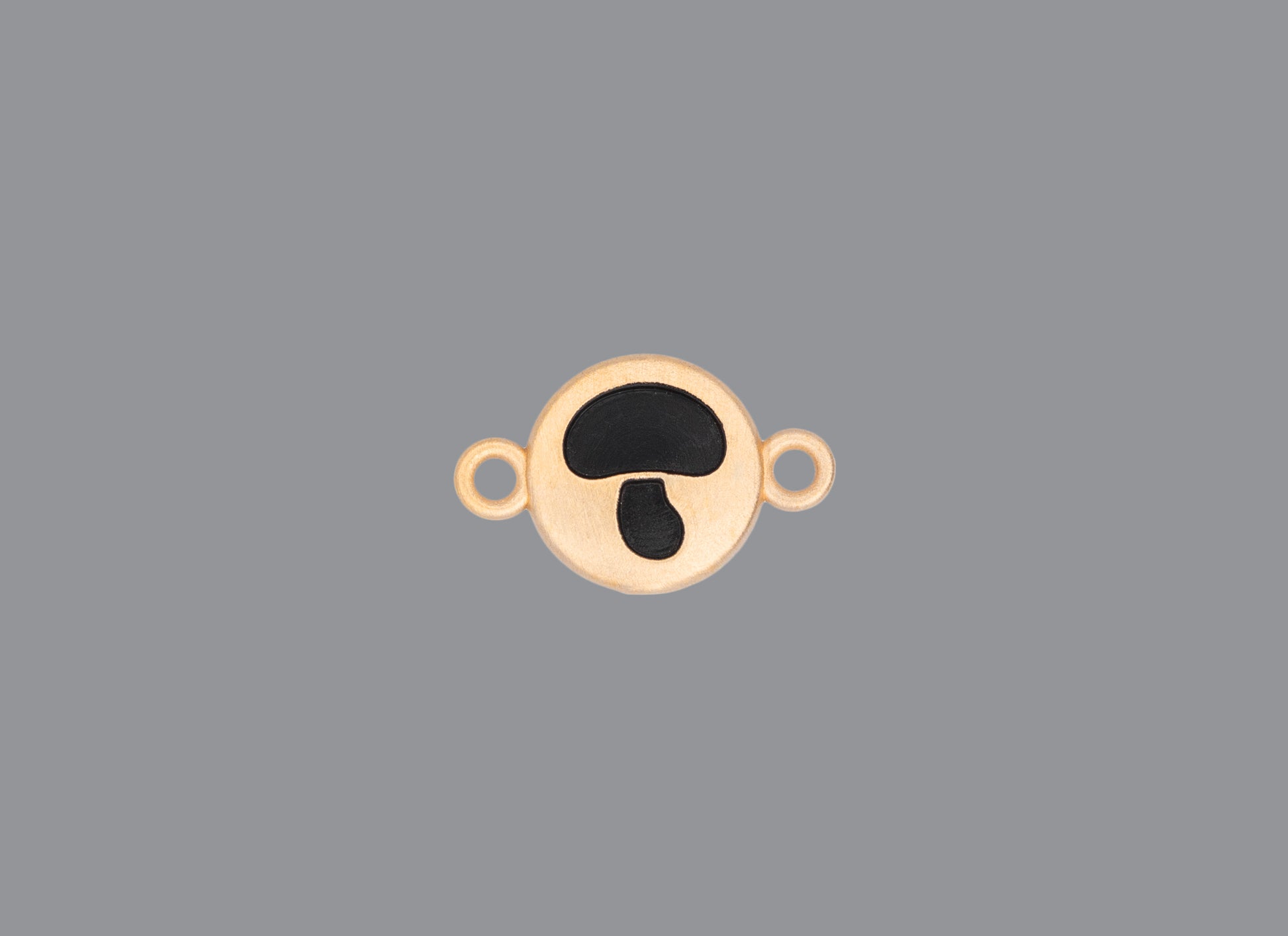 Round emoji connector in gold with a mushroom engraving on gray background