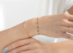 Two bracelets on a wrist against a white background