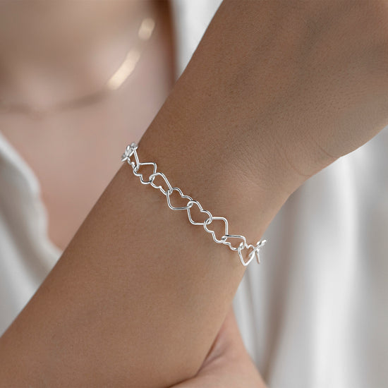 Sterling Silver bracelet on a person's wrist with a plain background