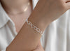 Sterling Silver bracelet on a person's wrist with a plain background