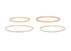 Four gold bangles on a white background