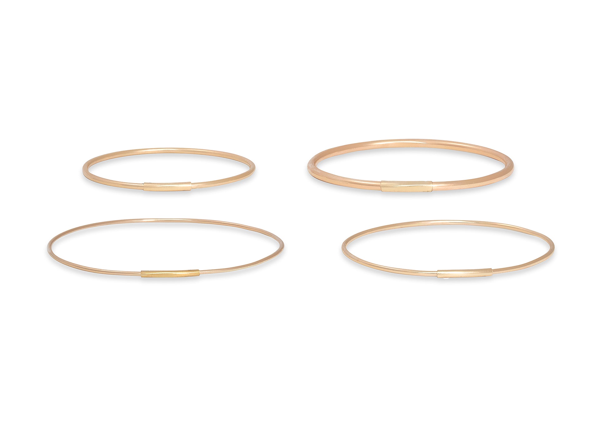 Four gold bangles on a white background