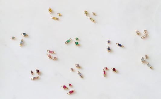 Small birthstone connectors with gemstones on a white background