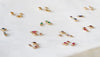 Small gold jewelry pieces with gemstones on a white surface