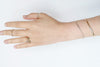 Hand wearing multiple rings on a white background