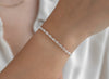 Silver chain on a wrist with a plain background