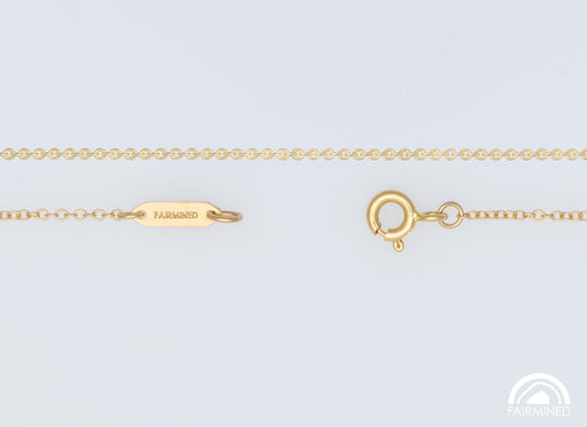 A fairmined gold cable chain necklace with a spring ring clasp and jump rings, laid out on a white background.