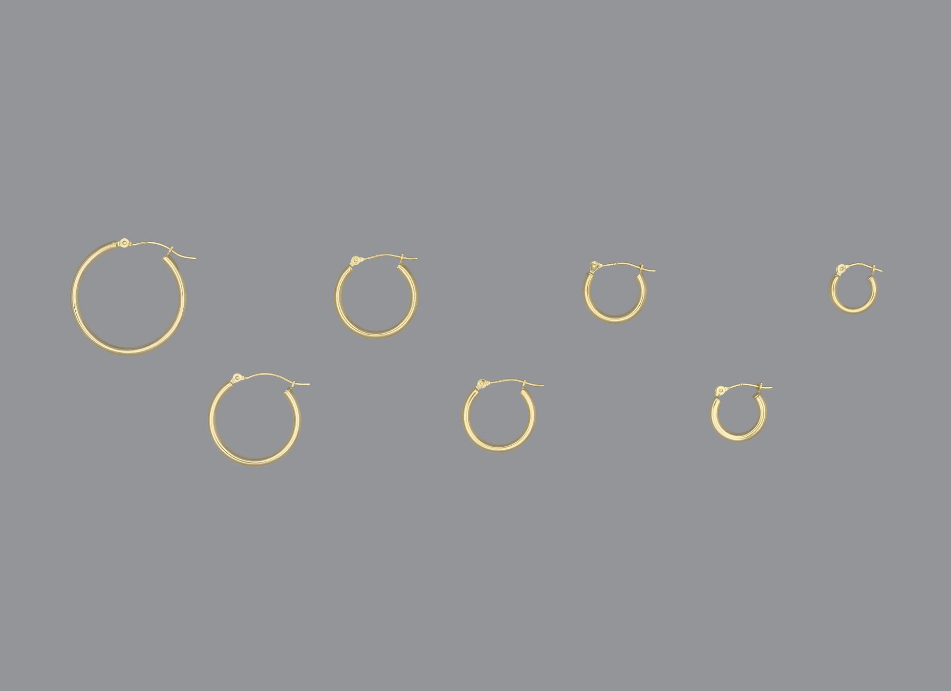 A collection of hoop earrings in ascending size order, made of 14KY gold, displayed against a grey background.